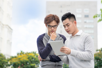 Smiling young businessman discussing surfing the Internet on the tablet