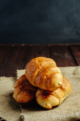 croissants on wooden table black background place for text