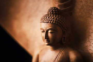Buddha in a meditation pose, under protection of the king of nag - Mukalinda. Figure isolated on a black background. - obrazy, fototapety, plakaty