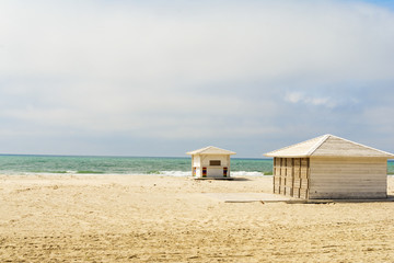 Empty beach. Off season in Black Sea. White beach huts next to the sea.