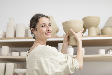Fototapeta premium Ceramist woman holding a potter in her studio