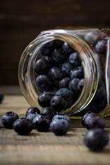Freshly scattered blueberries in a glass overturned jar