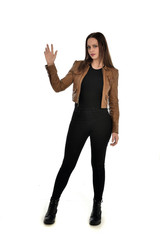 Fototapeta premium full length portrait of brunette girl wearing brown leather jacket. standing pose on white background.