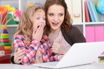 mother and daughter using laptop