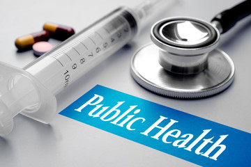 Public Health, health concept. Syringe, pills and stethoscope on grey background. Selective focus image.