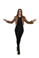 Fototapeta premium full length portrait of brunette girl wearing brown leather jacket. standing pose on white background.