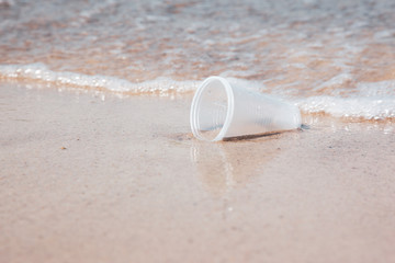 Plastic cups littering sea water at ocean beach