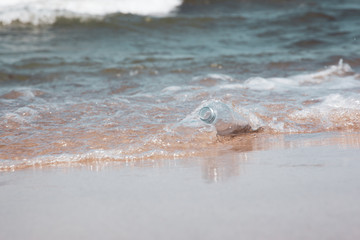 Fototapeta premium Plastic bottle in ocean water, littering the sea concept image