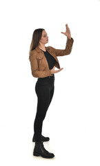 full length portrait of brunette girl wearing brown leather jacket.   standing pose on white background.