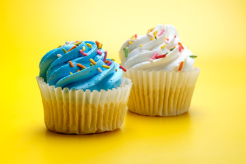 Tasty cupcakes on yellow background, selective focus
