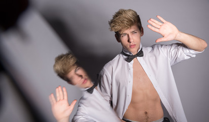 Sexy man in a classic white shirt with a bow tie