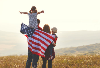 happy family with flag of america USA at sunset outdoors