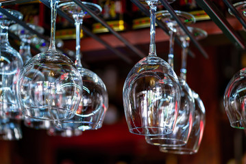 Wine glasses hanging on a rack in a bar. Glasses prepared for a party at the bar.