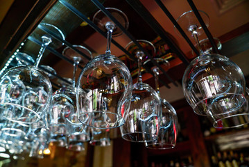 Glasses of wine hanging above a bar rack in restaurant.