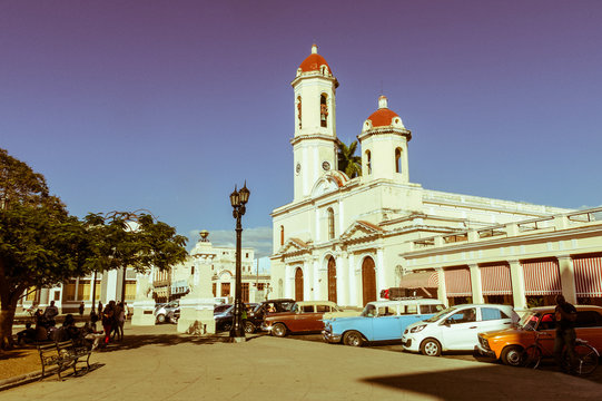 Vintage cars parked in the Jose Marti Park, in front of the Purisima Concepcion Cathedral. Cienfuegos, Cuba.