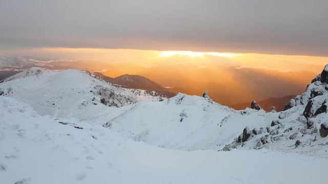 Spectacular sunset in the mountains during a cold winter day. Covered in snow