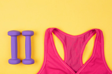 Sports and fitness accessories on yellow background. Flat lay, top view with place for text.