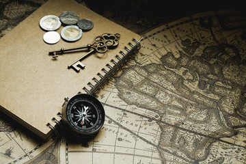 Fototapeta na wymiar Compass, antique keys and notebook on blur vintage world map, journey concept, copy space