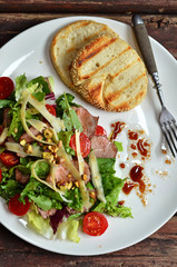 Salad with meat and tomatoes. Toasts on a white plate