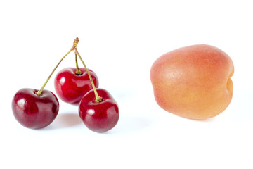 Pfirsich und Kirschen vor einem weißen Hintergrund