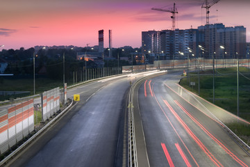 Traffic light trail on the road with accoustic barrier. Central ring road in Zvenigorod city. Moscow region Russia.