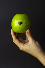 green apple in hand, fruit in hands