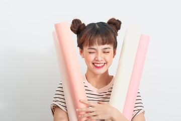 Portrait of a pretty woman in Striped t-shirt holds drawings in rolls standing over white background