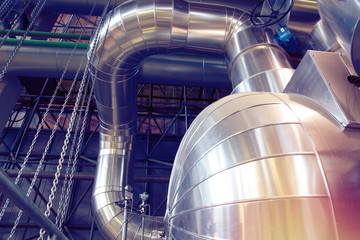 Equipment, cables and piping as found inside of a modern industrial power plant. Industrial zone, Steel pipelines, valves, cables and walkways