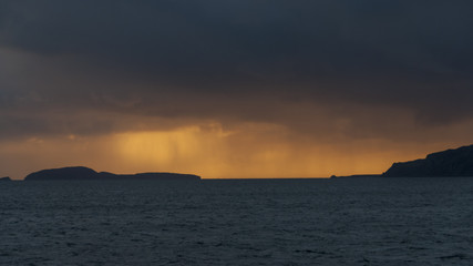Dramatic colourful and stormy sunset over the Sound of Sunda with the Island of Sunda and the Mull of Kintyre, Scotland