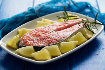 raw salmon with lemon on white dish