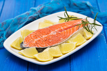 raw salmon with lemon on white dish