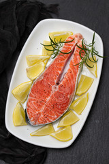 raw salmon with lemon on white dish