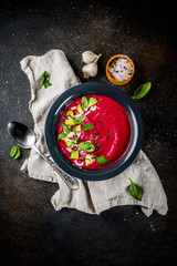 Vegan food, summer cold Beetroot gazpacho soup with lemon, avocado and fresh herbs copy space top view