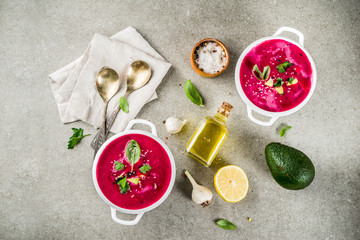 Vegan food, summer cold Beetroot gazpacho soup with lemon, avocado and fresh herbs copy space top view