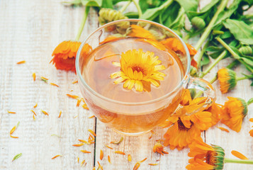 calendula tea and flowers. Selective focus. 