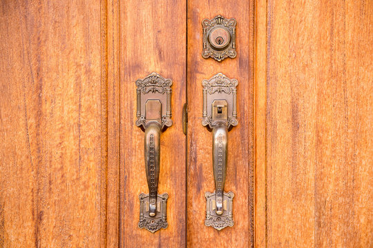 Vintage brass door handle with lock on wooden door