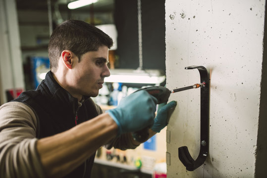 Man fixing a bracket with an electric screwdriver