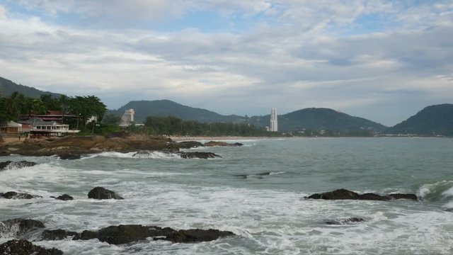 sea wave hit the rock shore seascape , Patong sand beach Phuket  parasail , tree and mountain are  background ,
