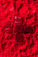 top view of candies in shape of cross on red powder
