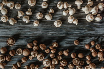 top view of separated white and brown champignon mushrooms on wooden surface