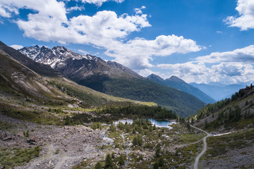 Fototapeta na wymiar Mountain valley with road and alpine lake