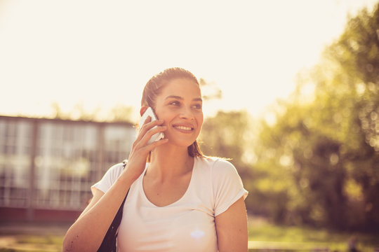 Close up image of young sport woman talking phone.