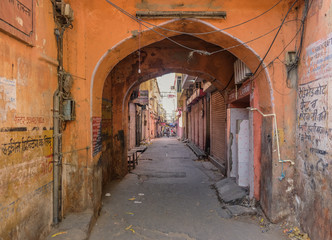 Fototapeta na wymiar Jaipur, Rajastan, India - April 1, 2018: A lonely and narrow street in the center of the pink city of Jaipur