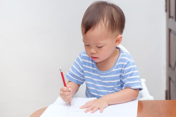 Cute Asian 2 years old toddler baby boy child writing / drawing with pencil, Preschooler doing homework, Creative play for toddler, Little kid prepare for kindergarten entrance exam, Shallow DOF