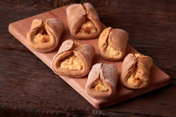 Cookies with cottage cheese - sochnik on wooden desk. Classic colors. Warm photo