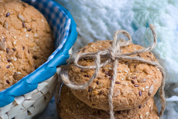 homemade oat cookies with sunflower seeds in and near blue checkered basket on white and blue plaid