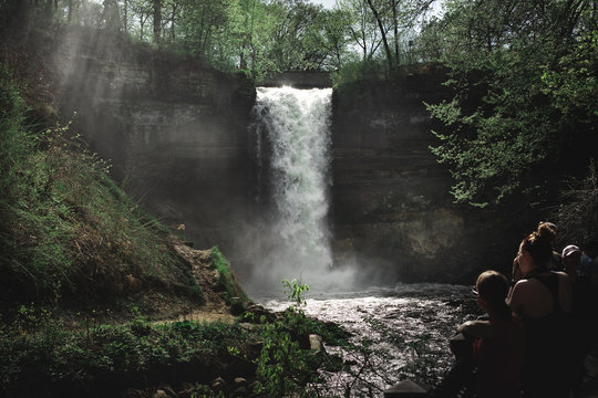 Moody shot of waterfall with mist and people looking on