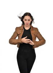 portrait of brunette girl wearing brown leather jacket.   white studio background