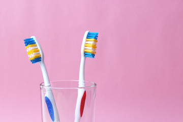 toothbrushes in a glass on a colored background. oral health, brush your teeth, healthy teeth