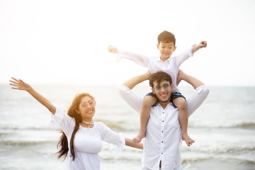 Active parents and people outdoor activity on summer vacations and holiday with children.Happy family and son walk with fun of sunset sea on sand beach.